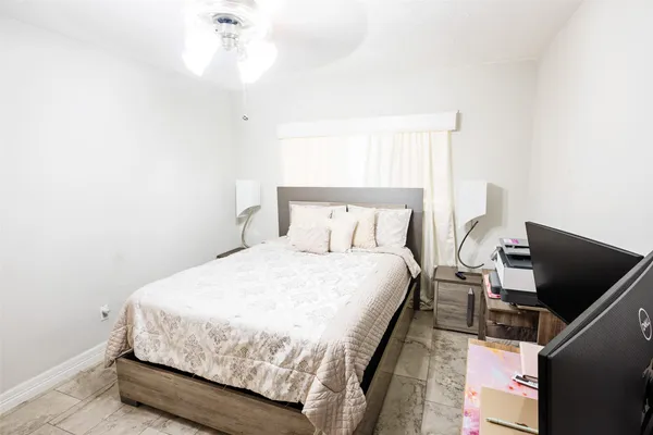 a bed sitting in a bedroom next to a window with a chandelier