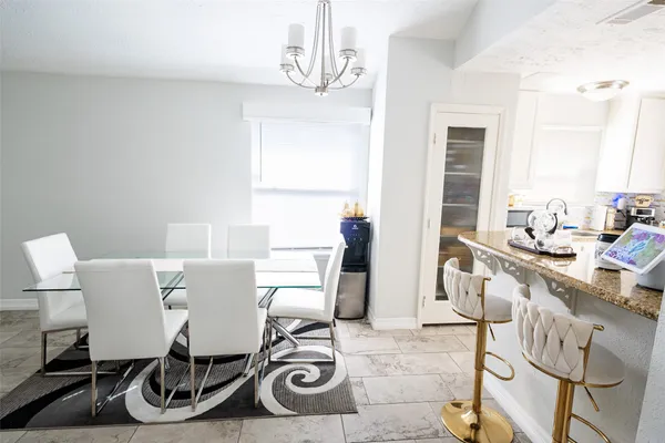 a view of a dining room with furniture a chandelier and wooden floor
