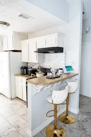 a kitchen with granite countertop a stove a refrigerator and a stove
