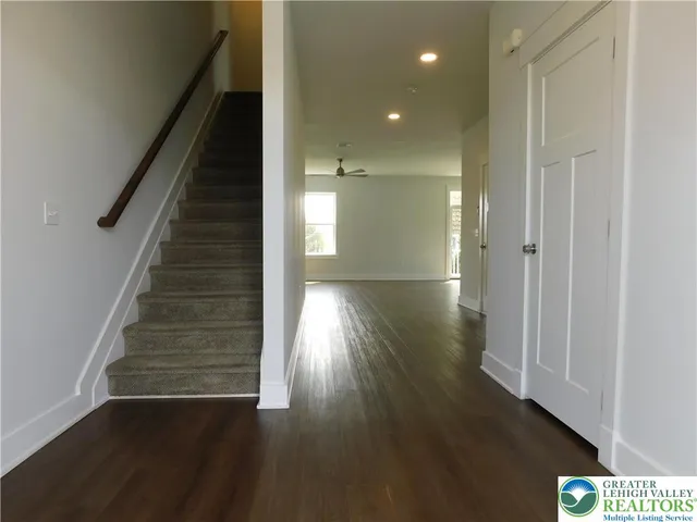 a view of a hallway with wooden floor and staircase