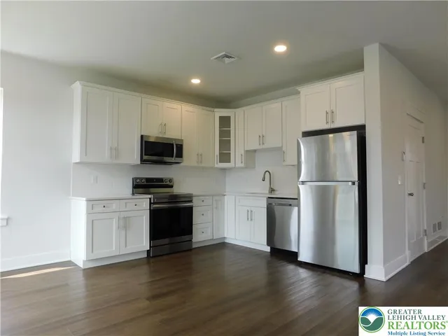 a kitchen with a refrigerator stove and wooden cabinets