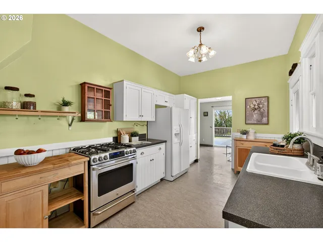 a kitchen with stainless steel appliances a stove a sink dishwasher and a refrigerator with wooden floor