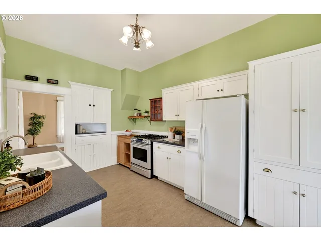 a kitchen with granite countertop a refrigerator a stove a sink and dishwasher