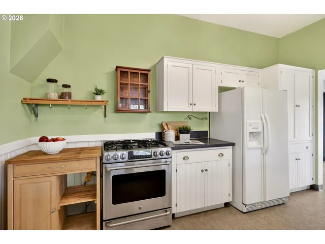 a kitchen with stainless steel appliances white cabinets and a stove top oven