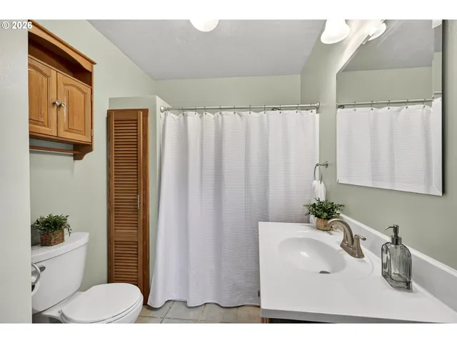 a bathroom with a sink a toilet and shower curtain