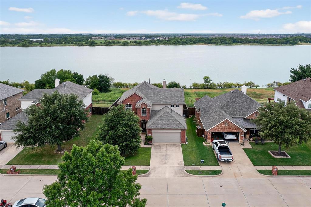 an aerial view of a house with outdoor space and lake view in back