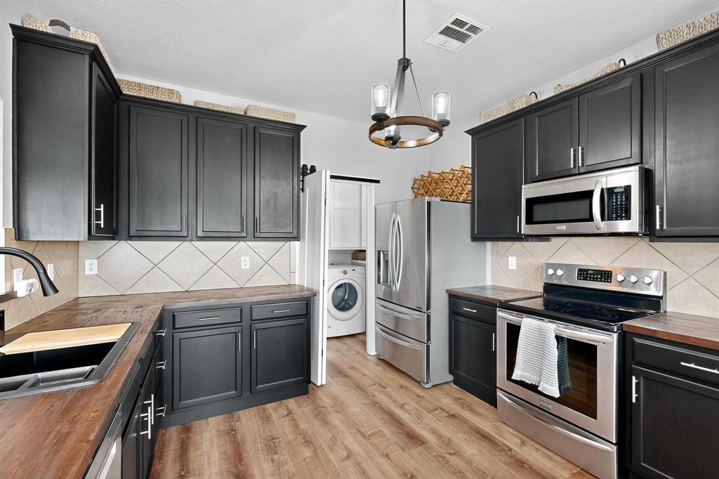 2820 Appaloosa Court Little Elm, TX 75068 - Photo 10 of 40 a kitchen with stainless steel appliances granite countertop a stove and a refrigerator