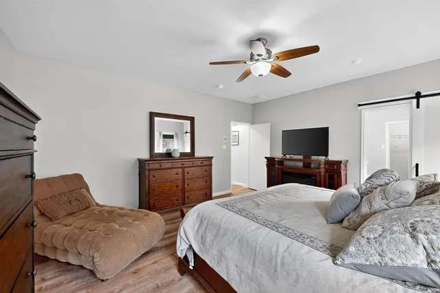 a bedroom with a bed ceiling fan and a window
