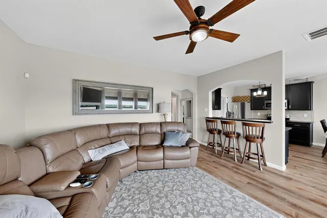 a living room with furniture and a wooden floor