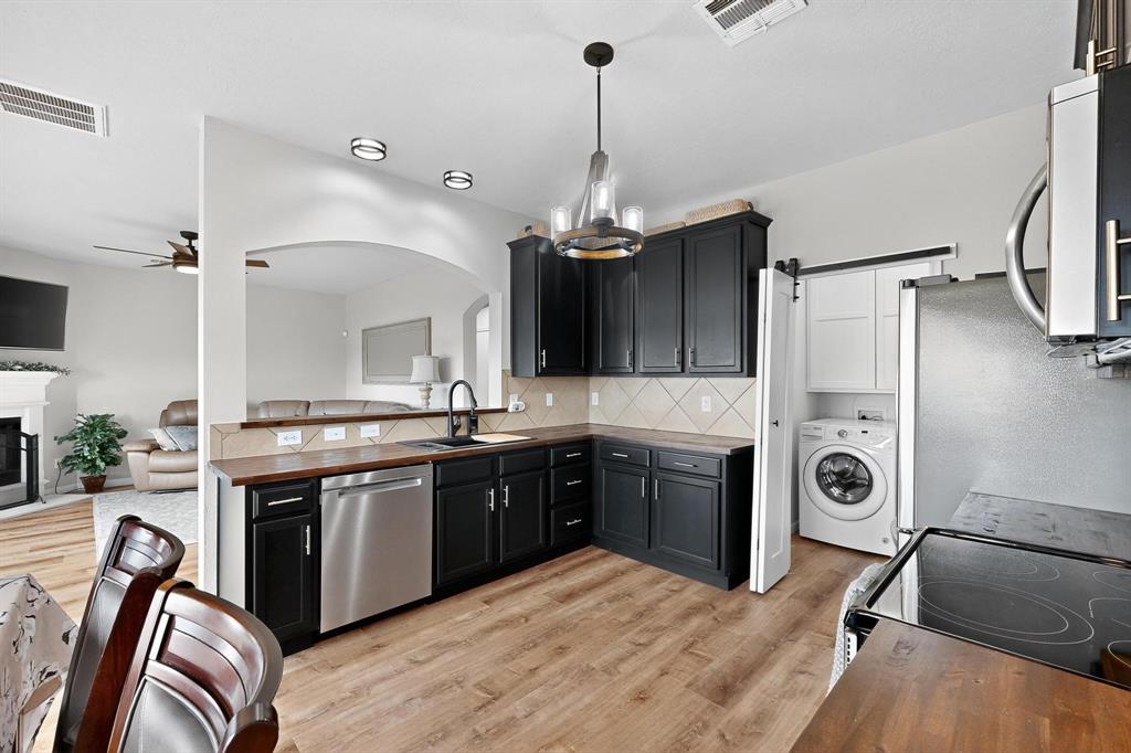 2820 Appaloosa Court Little Elm, TX 75068 - Photo 9 of 40 a kitchen with stainless steel appliances granite countertop a stove a sink and a refrigerator