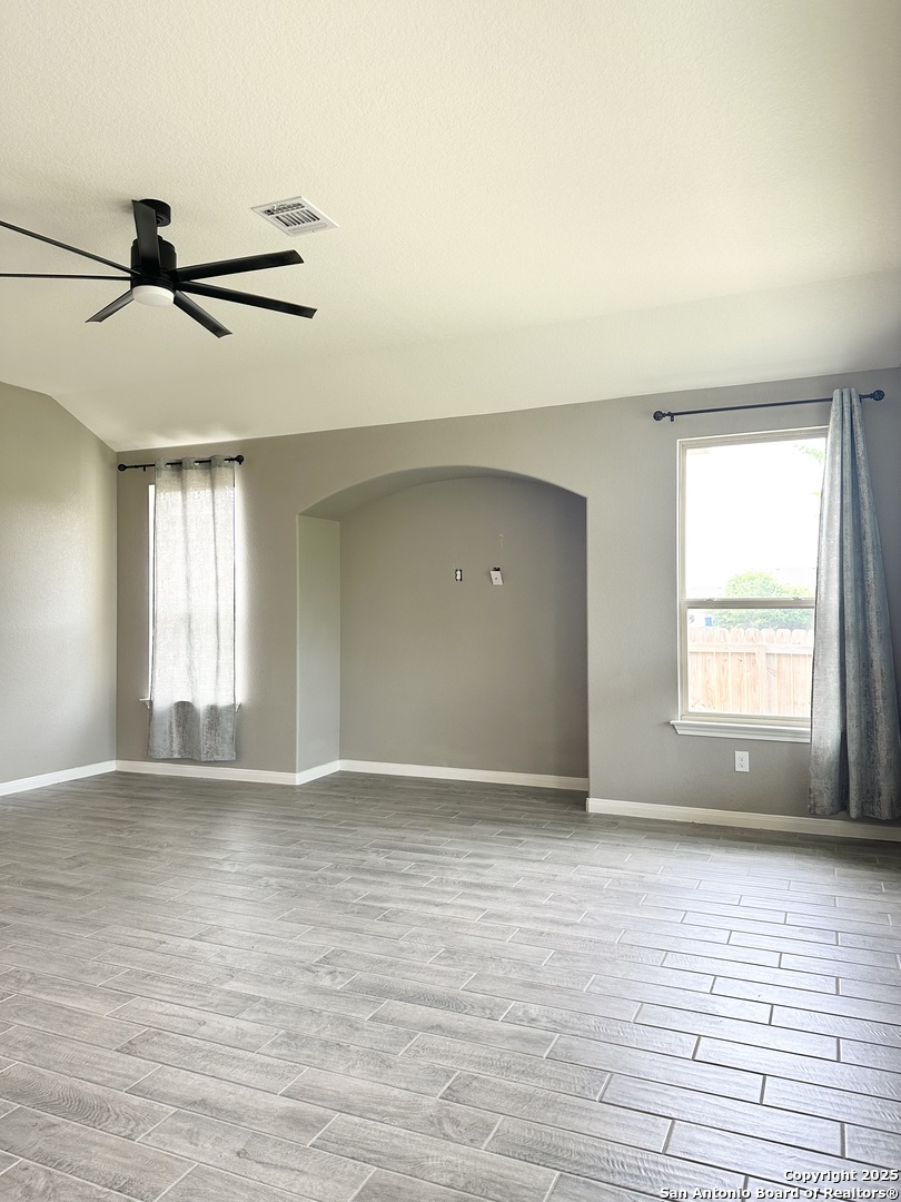 218 Iron Gate Pleasanton, TX 78064 - Photo 6 of 15 a view of an empty room with window and wooden floor