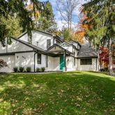 a view of a house with a big yard and large tree