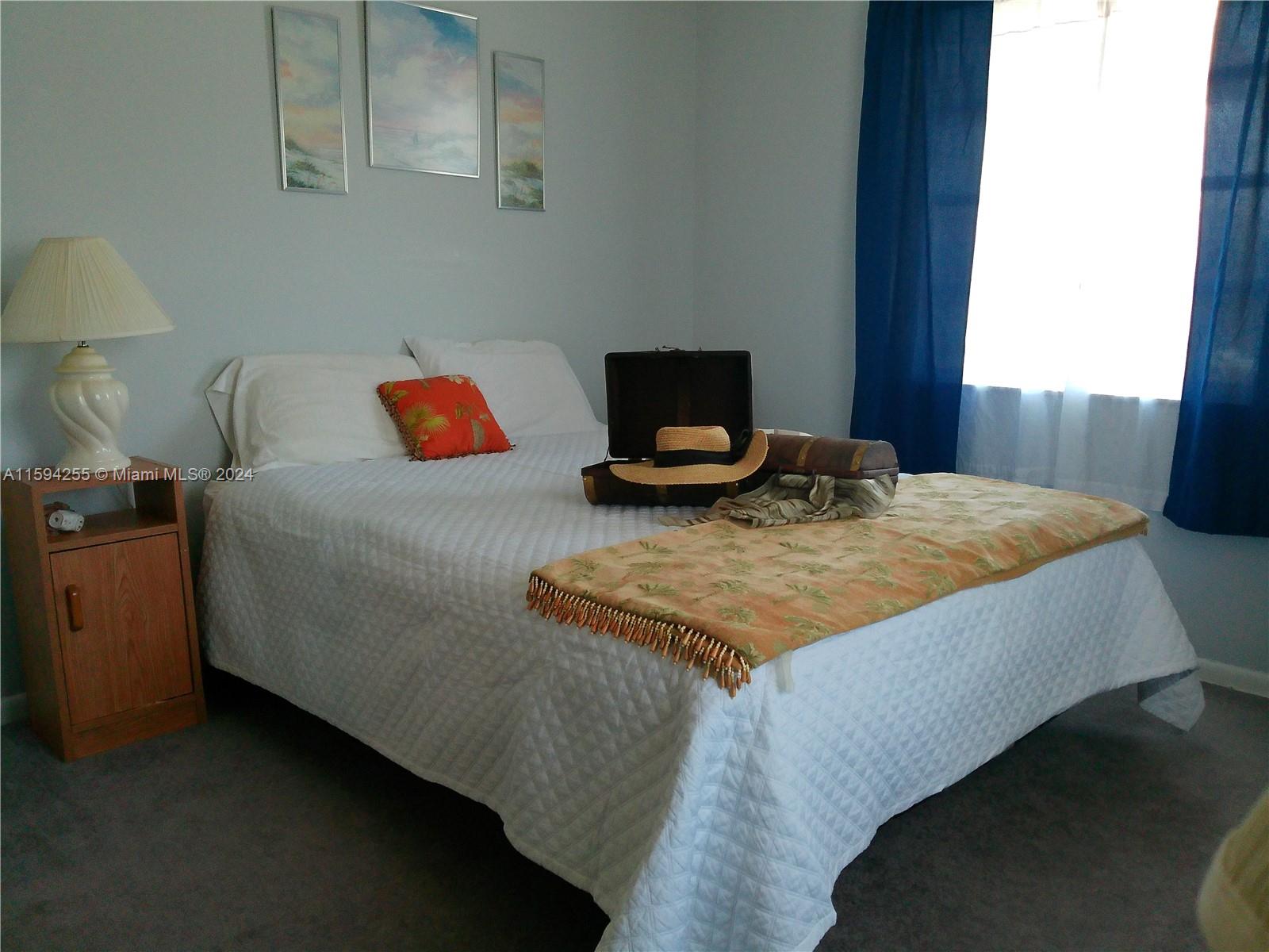 1100 East Indiantown Road, Unit 110 Jupiter, FL 33477 - Photo 13 of 19 a bed sitting in a bedroom next to a window