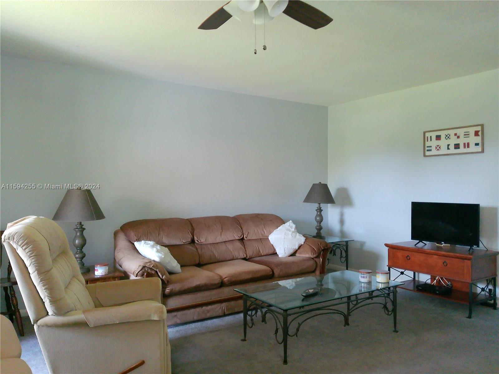 1100 East Indiantown Road, Unit 110 Jupiter, FL 33477 - Photo 4 of 19 a living room with furniture and a flat screen tv