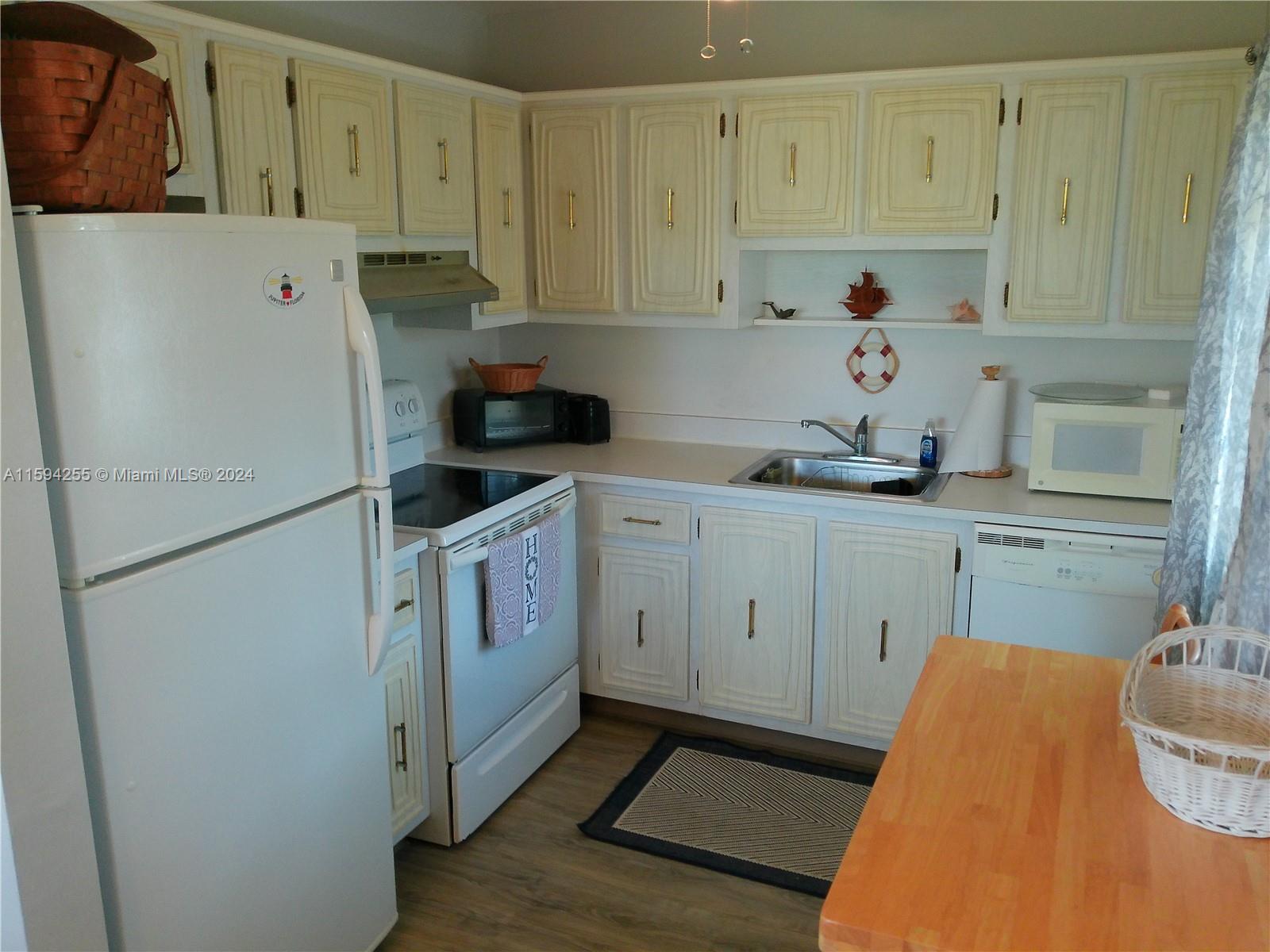 1100 East Indiantown Road, Unit 110 Jupiter, FL 33477 - Photo 6 of 19 a kitchen with a refrigerator sink and cabinets