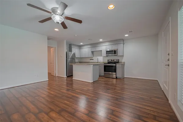 an open kitchen with kitchen island white cabinets and stainless steel appliances