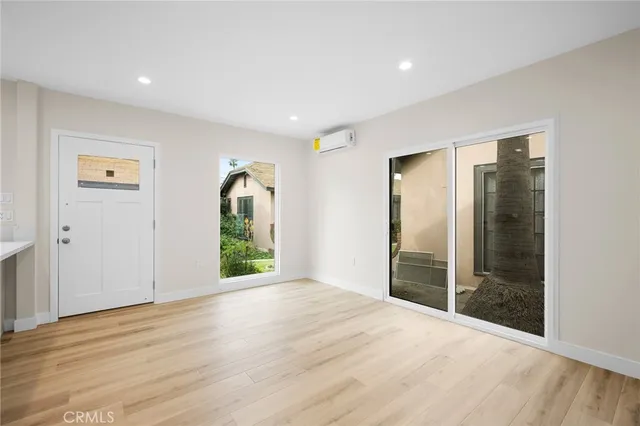 a view of a big room with wooden floor and windows