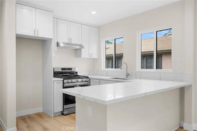 a kitchen with stainless steel appliances granite countertop a sink and a stove