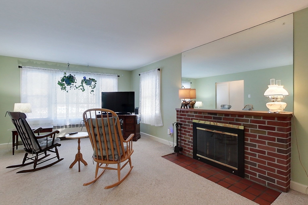 19 Mill Road Littleton, MA 01460 - Photo 11 of 31 a living room with furniture a fireplace and a flat screen tv