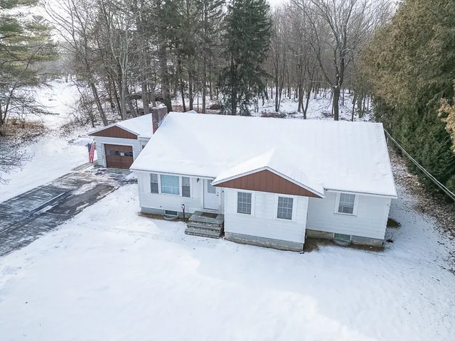 an aerial view of a house with a yard and parking