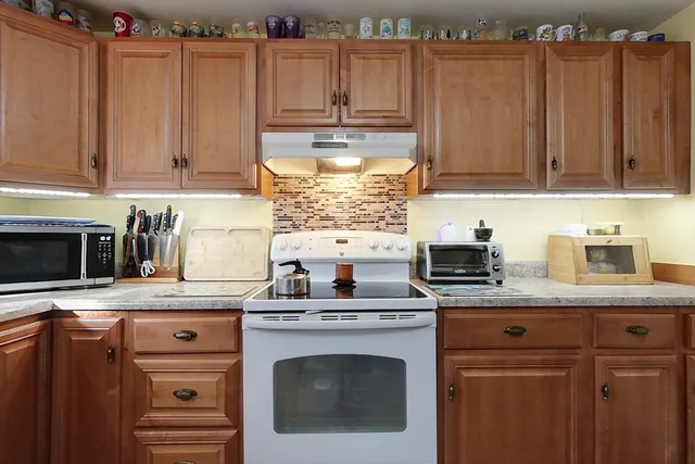 a kitchen with granite countertop a sink stove and cabinets