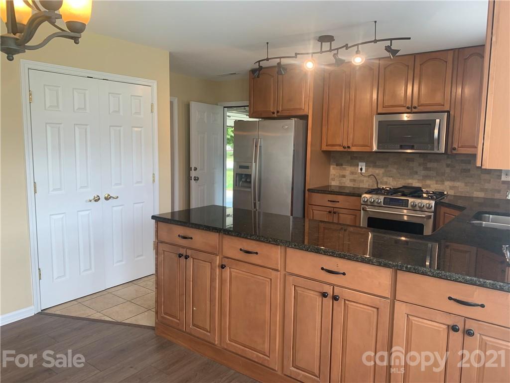 136 Royalton Road Mooresville, NC 28115 - Photo 9 of 28 a kitchen with granite countertop a refrigerator and microwave