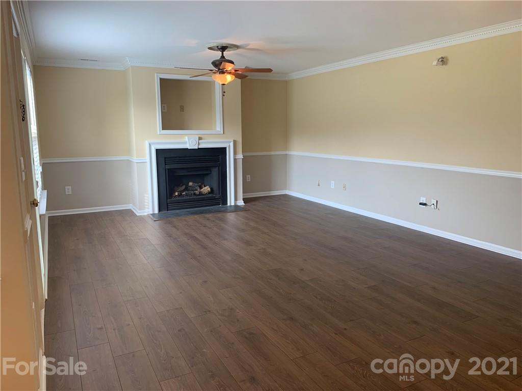 136 Royalton Road Mooresville, NC 28115 - Photo 10 of 28 a view of an empty room with wooden floor fireplace and a window