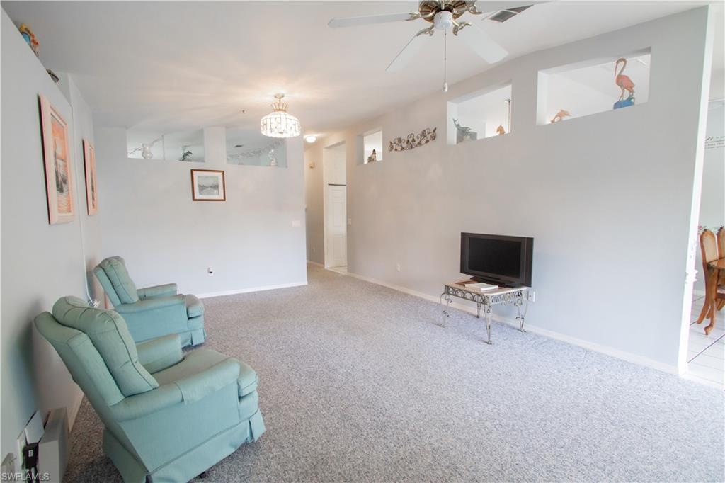 7648 Oleander Gate Drive, Unit 202 Naples, FL 34109 - Photo 11 of 23 a living room with furniture and a flat screen tv