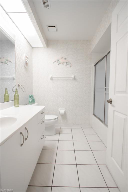 7648 Oleander Gate Drive, Unit 202 Naples, FL 34109 - Photo 17 of 23 a bathroom with a sink a toilet and a mirror