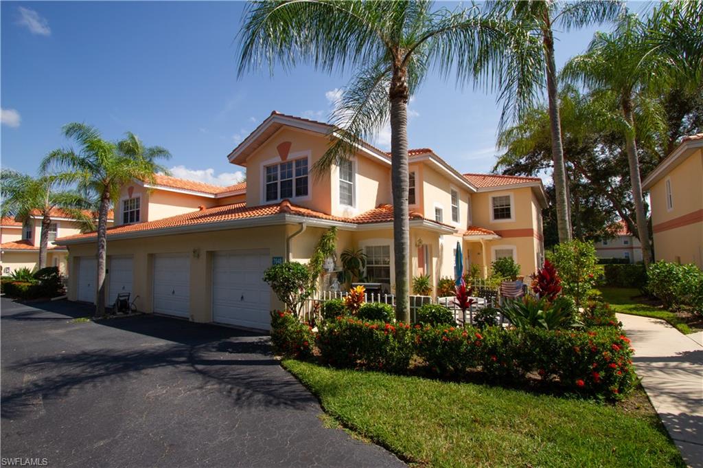 7648 Oleander Gate Drive, Unit 202 Naples, FL 34109 - Photo 2 of 23 a front view of house and yard with green space
