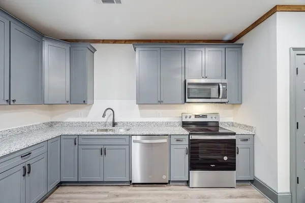 a kitchen with stainless steel appliances granite countertop a sink and a microwave