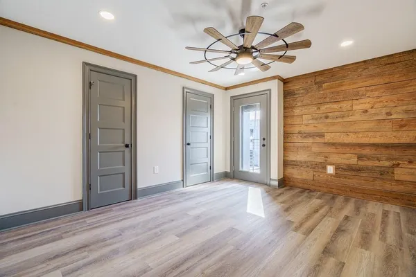 a view of a livingroom with wooden floor and a ceiling fan
