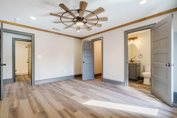 a view of a hallway with wooden floor and a chandelier