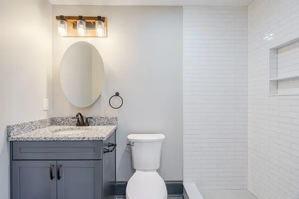 a bathroom with a toilet sink and mirror