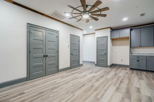 wooden floor in an empty room with a kitchen