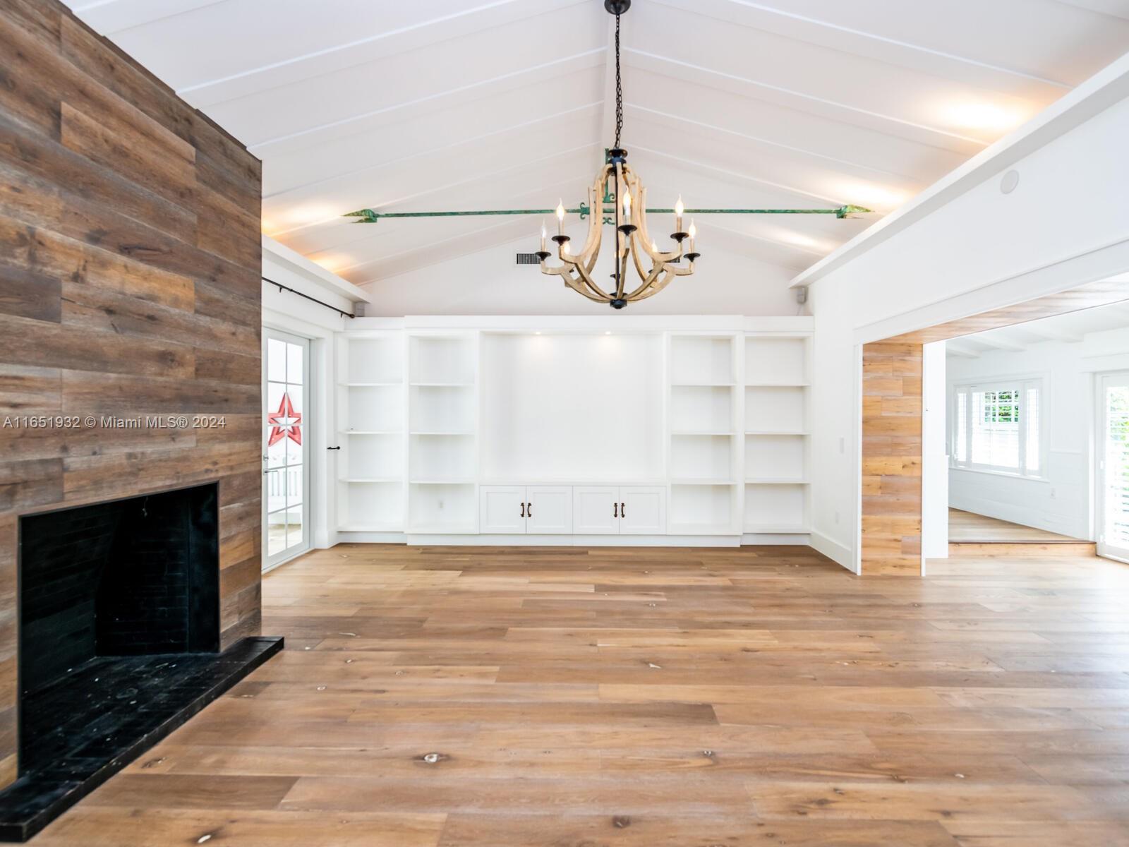 4700 Lake Road Miami, FL 33137 - Photo 23 of 92 a view of a livingroom with a fireplace a chandelier and wooden floor