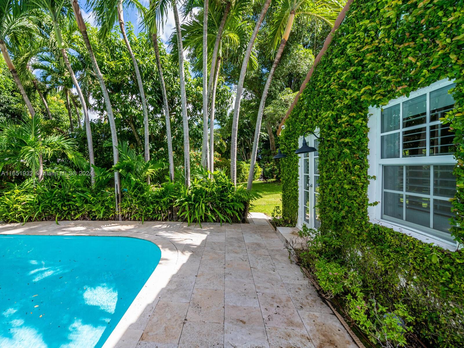 4700 Lake Road Miami, FL 33137 - Photo 77 of 92 a view of a backyard with potted plants and large trees