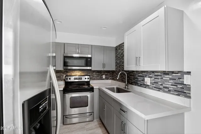 a kitchen with a sink and steel appliances