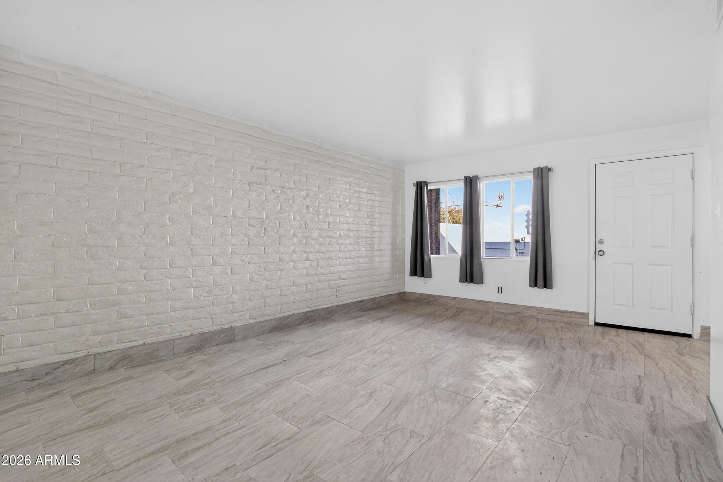 2925 North 38th Street, Unit 2 Phoenix, AZ 85018 - Photo 8 of 19 a view of an empty room with wooden floor and windows