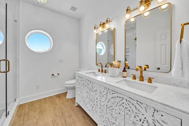 a dining room with chandelier fan and wooden floor