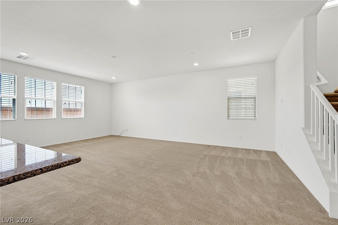155 Fulgora Street Henderson, NV 89074 - Photo 4 of 30 A spacious room offers comfortable carpeting, recessed lighting, and ample natural light from multiple windows.