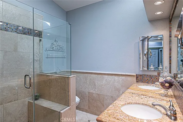 a bathroom with a granite countertop sink a mirror and shower