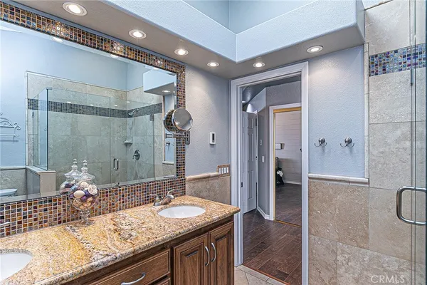 a bathroom with a granite countertop sink mirror and shower