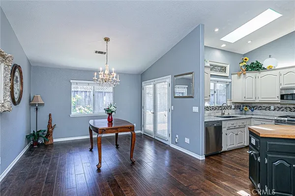 a living room with stainless steel appliances kitchen island granite countertop wooden floors and a view of living room