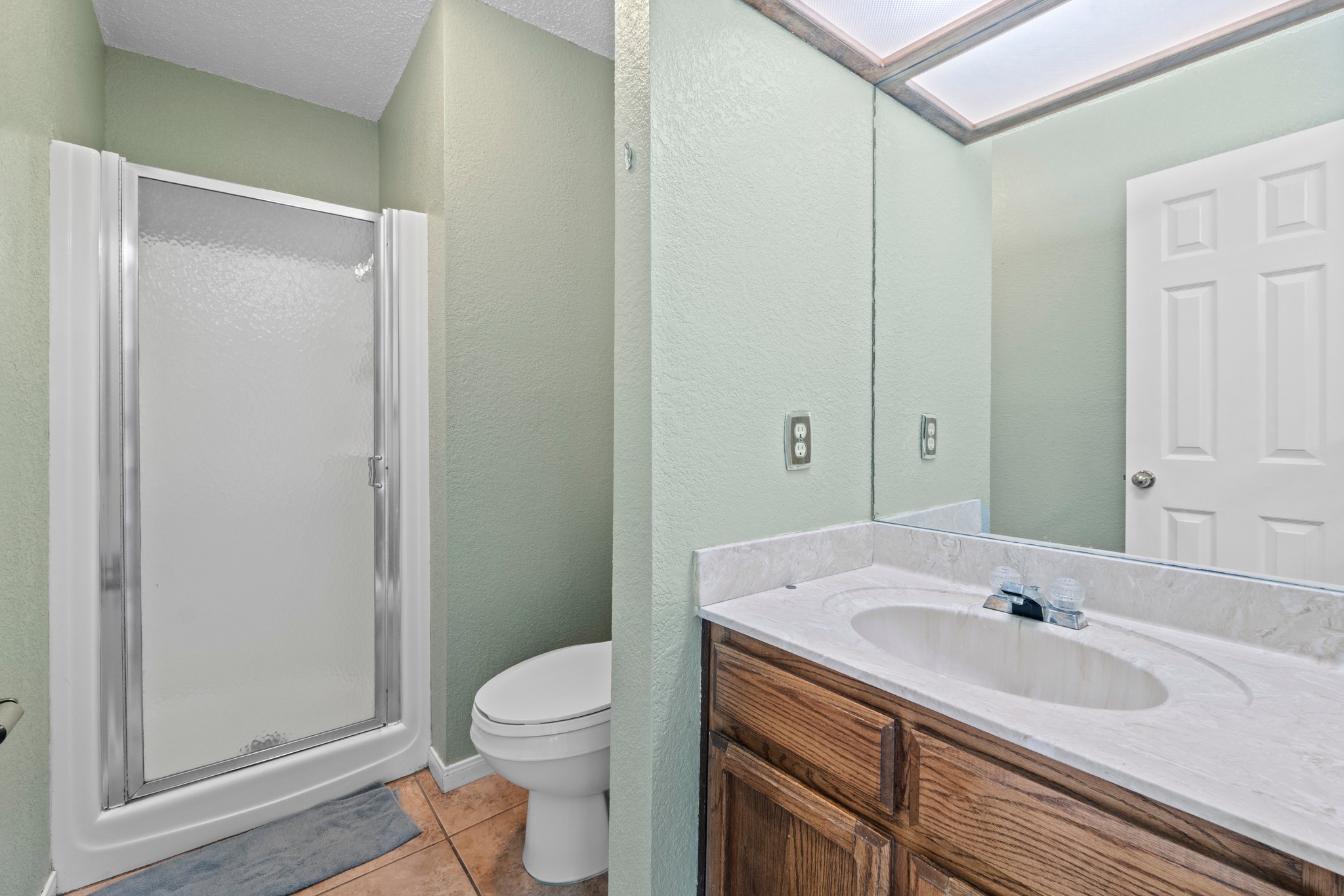 205 Sedro Trail Georgetown, TX 78633 - Photo 24 of 32 A well-lit bathroom features a glass-enclosed shower alongside a vanity with ample counter space.