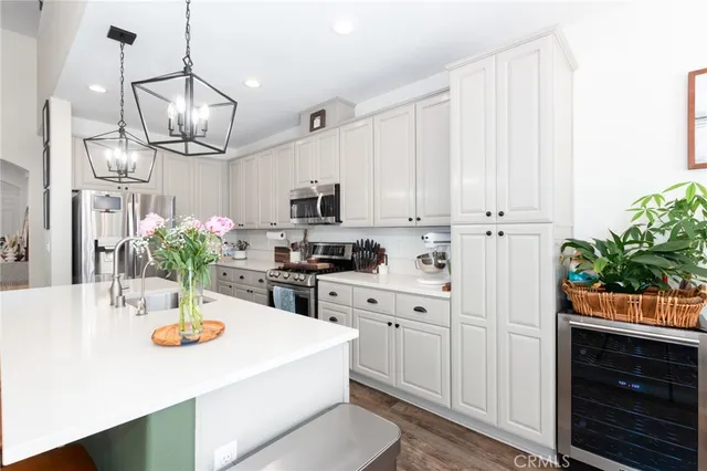 a kitchen with stainless steel appliances kitchen island granite countertop a sink a stove a dining table and chairs