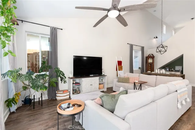 a living room with furniture kitchen view and a chandelier