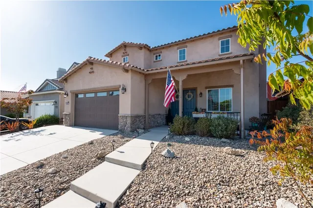 a view of a white house with a small yard and plants