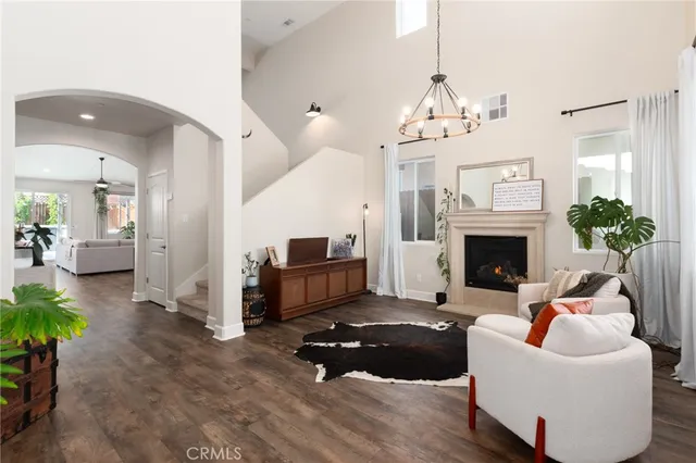 a living room with furniture a fireplace and a chandelier
