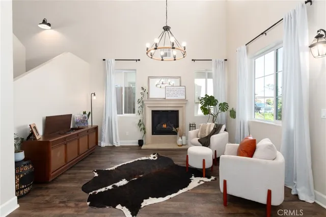 a living room with furniture a fireplace and a chandelier